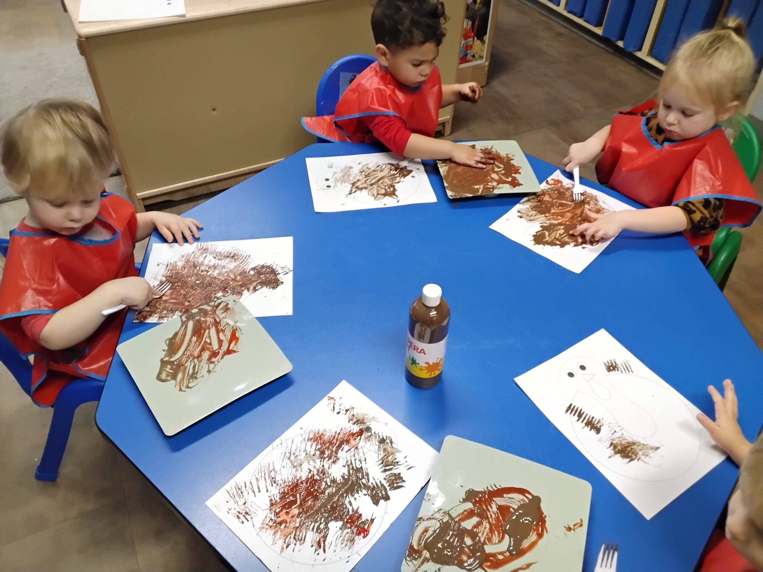 preschoolers painting with fall colors