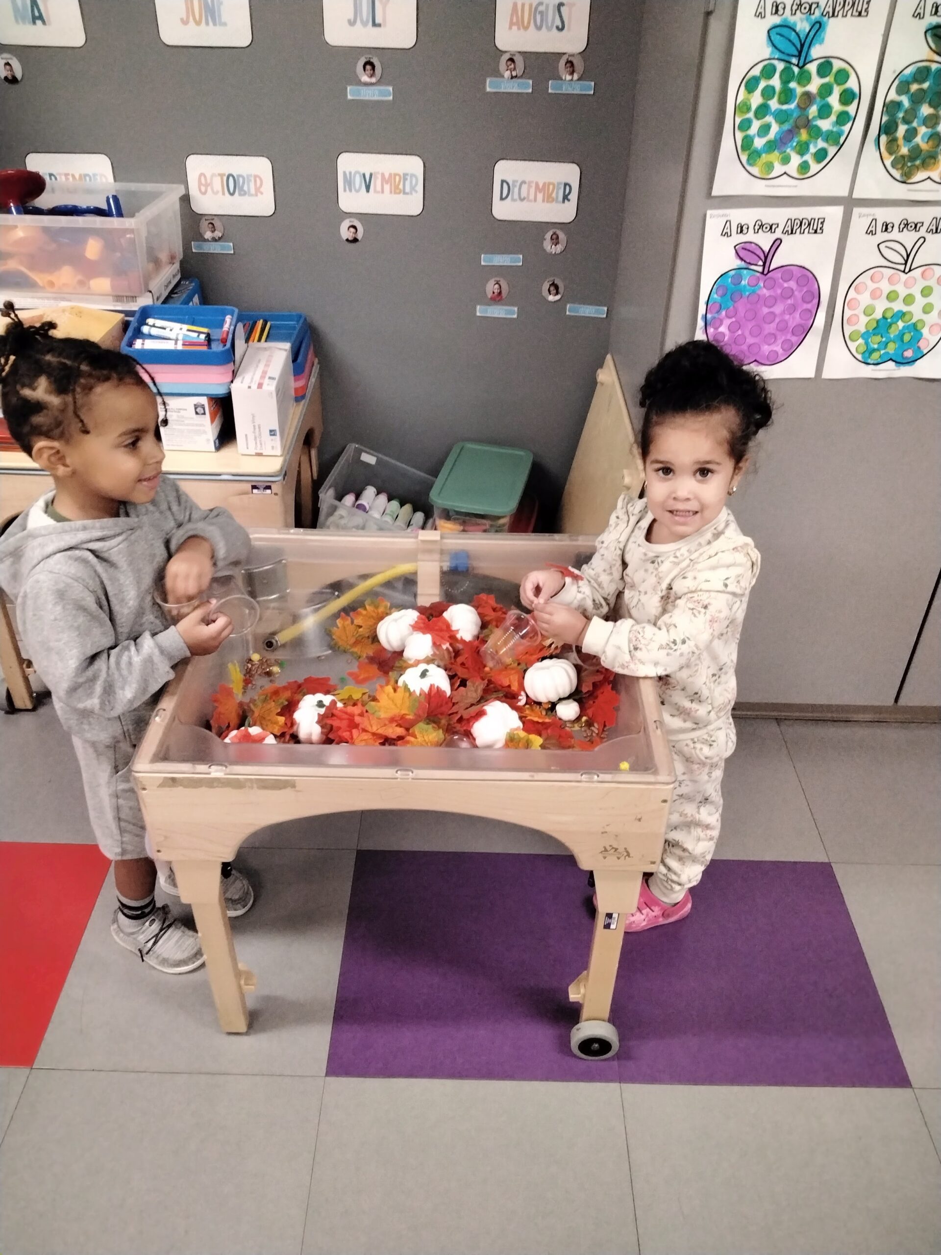 Preschoolers playing in a Fall sensory Bin