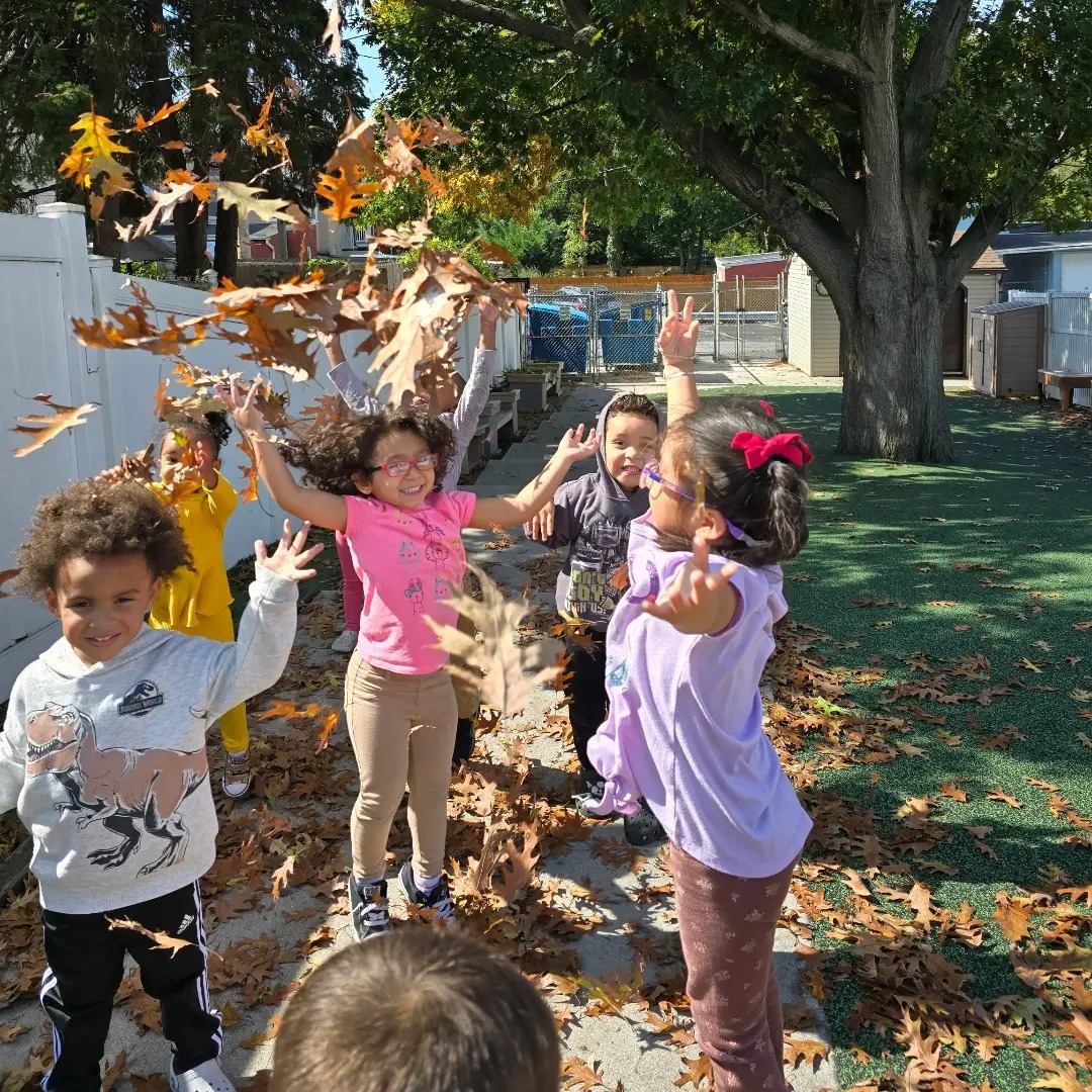Children playing in Leaves at Lancaster Early Education Center